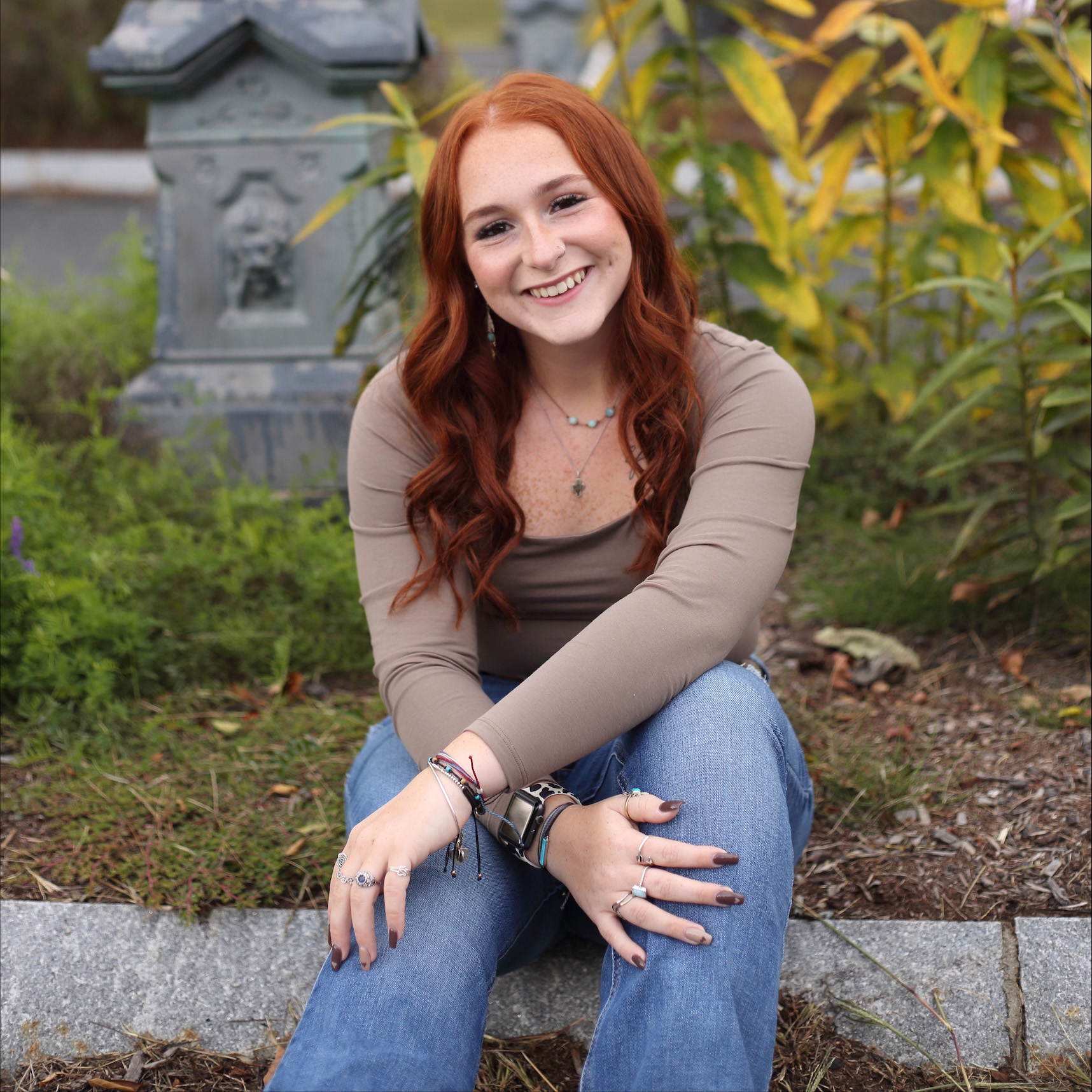 A woman smiles in a portrait taken in a garden.