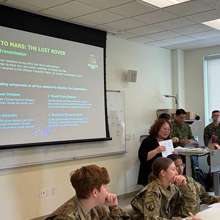 Cadets and other participants gather in a classroom during a Mission to Mars cybersecurity presentation.